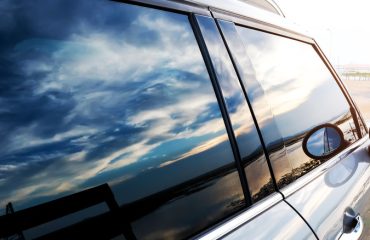 Car window reflecting sky