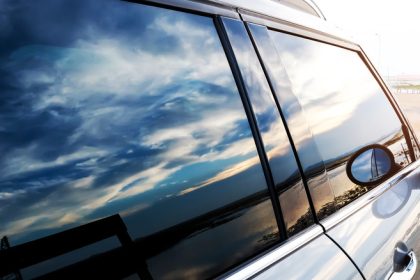 Car window reflecting sky