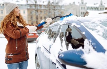 woman cleaning snow from car