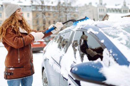 woman cleaning snow from car