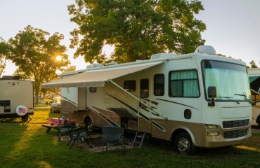 Rv parked in the grass with other RVs around