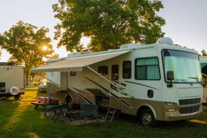 Rv parked in the grass with other RVs around