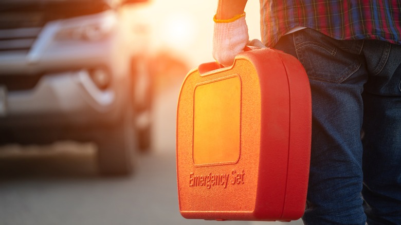 person with orange emergency set walking toward truck