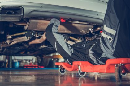 mechanic working on car undercarriage