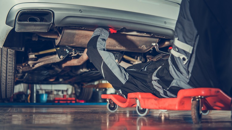 mechanic working on car undercarriage