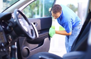 A Man Cleaning The Inside Of A Car