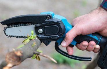 Small handheld chainsaw in use