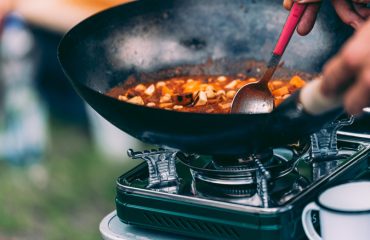 person cooking on camping stove