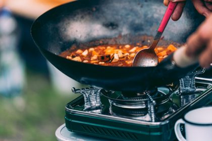 person cooking on camping stove