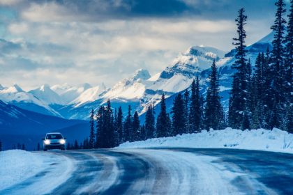 Car driving down snowy road